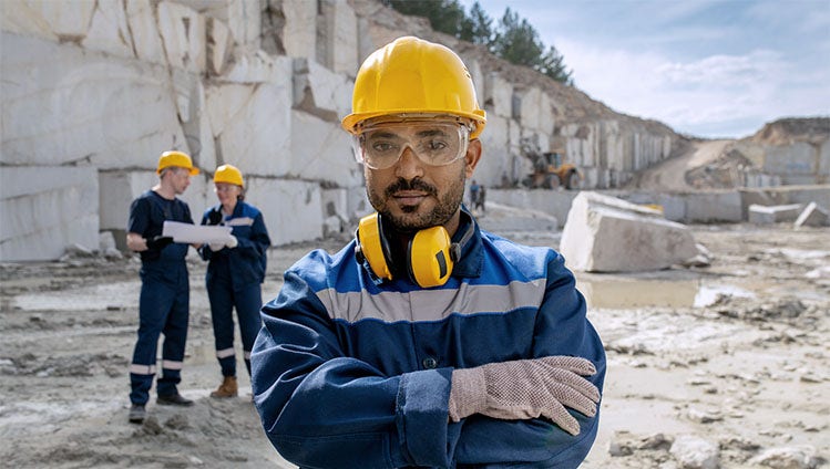 Young serious builder in workwear standing at workplace; Shutterstock ID 1982461595; purchase_order: -; job: -; client: -; other: -